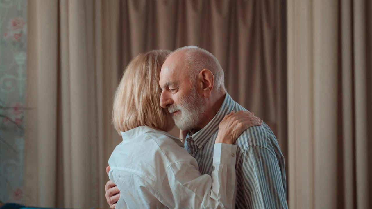 A senior couple embracing each other tenderly.