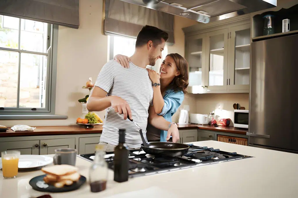 Woman embracing her partner while he cooks
