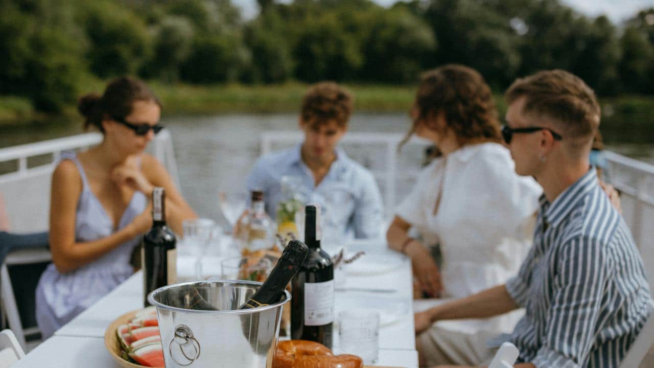 A group of friends having lunch on a boat by the water.