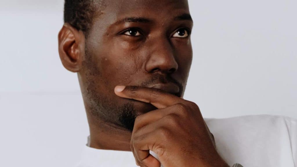 A man resting his hand on his chin looking thoughtful