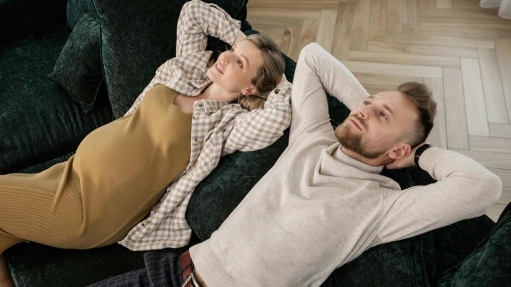 A couple lying on a couch relaxing side by side