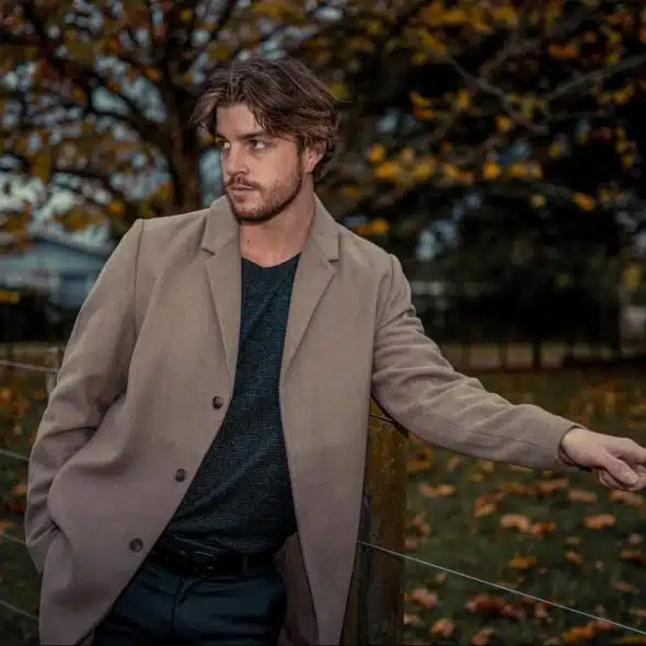 A man leaning on a fence.
