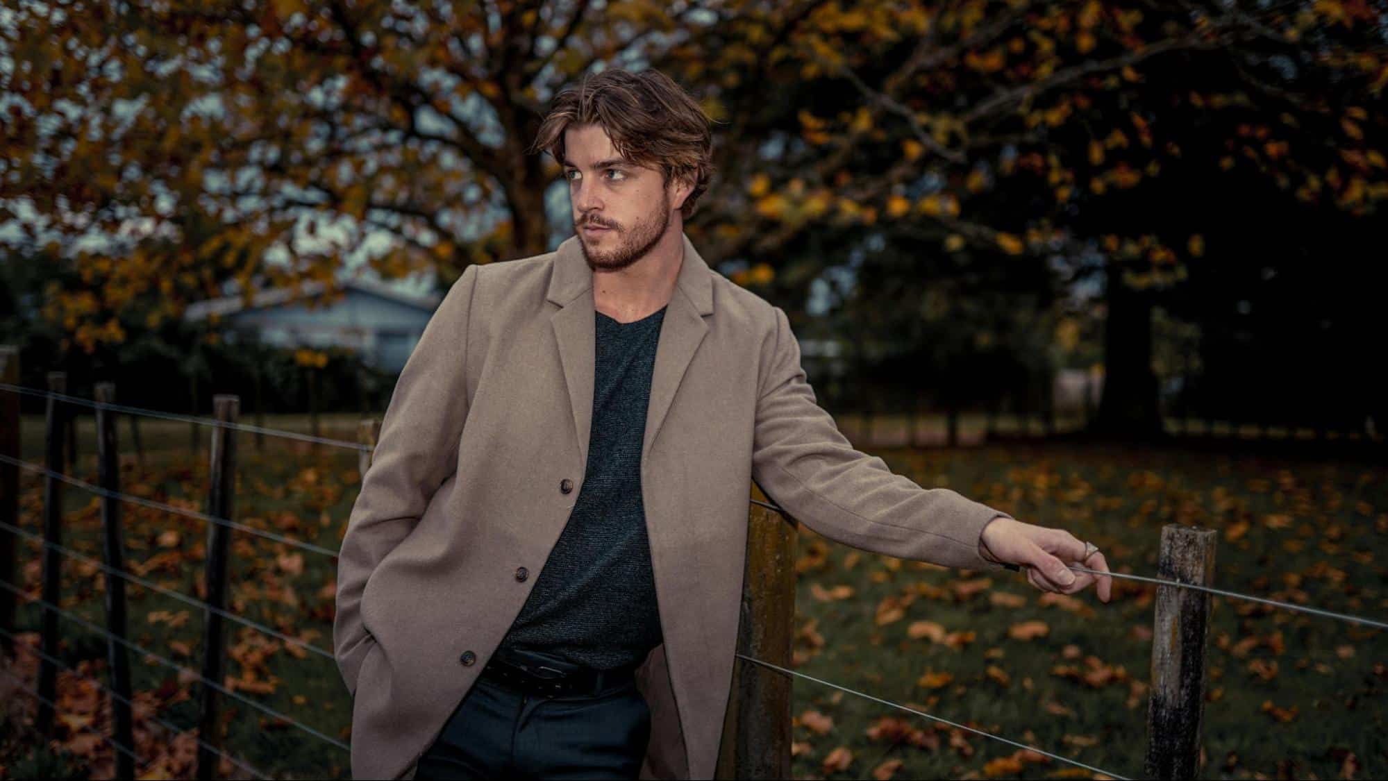 A man leaning on a fence.