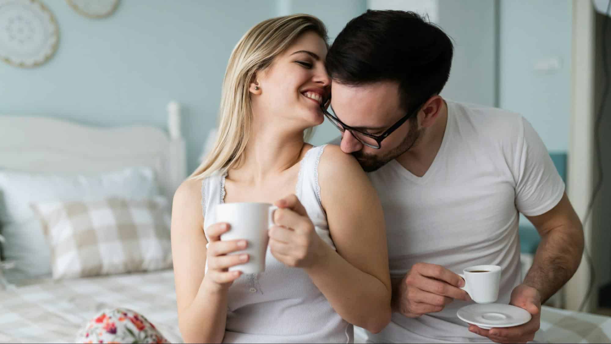 A man kissing woman’s shoulder
