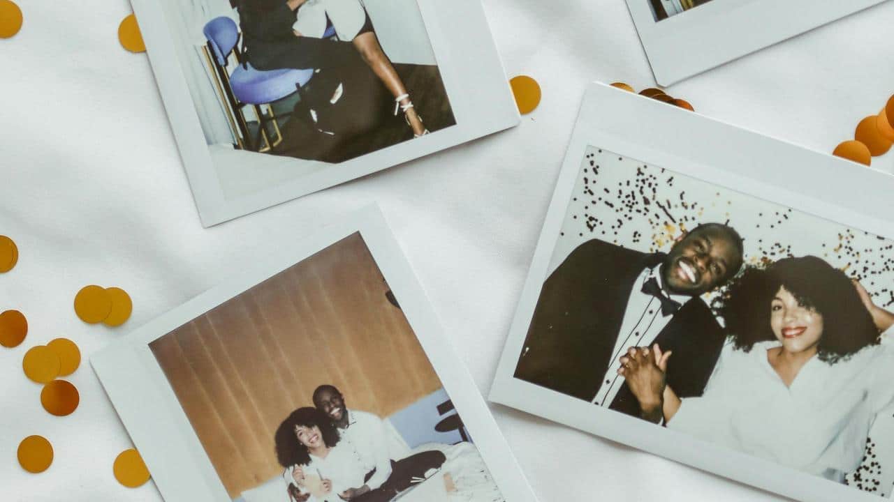 A collection of instant photos showing a smiling couple and moments together on a table.