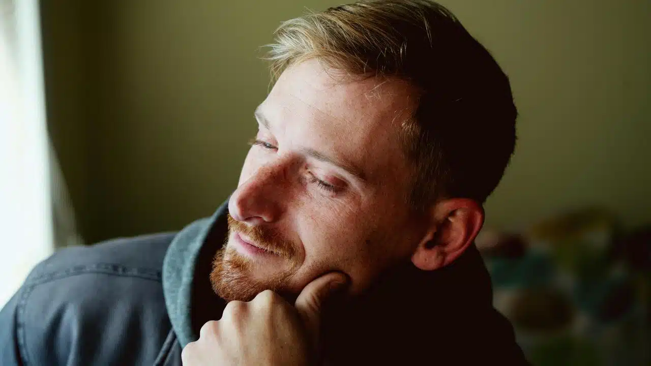 A man with light hair and a beard smiling