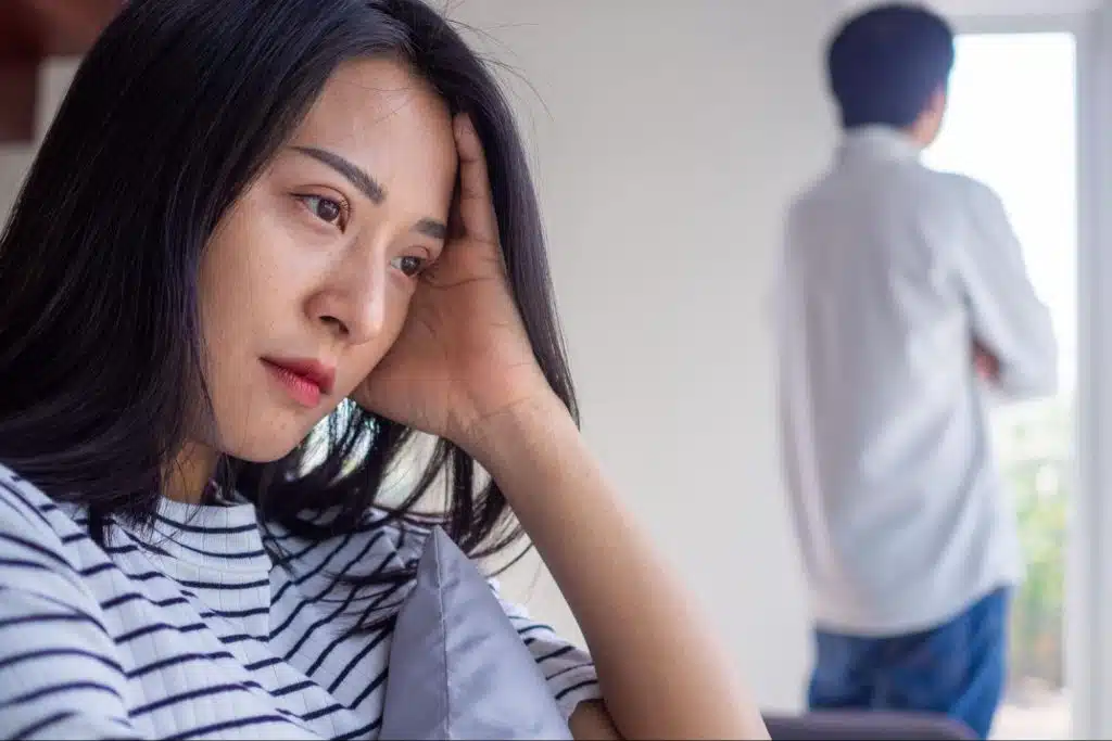 Disappointed woman with man standing in background