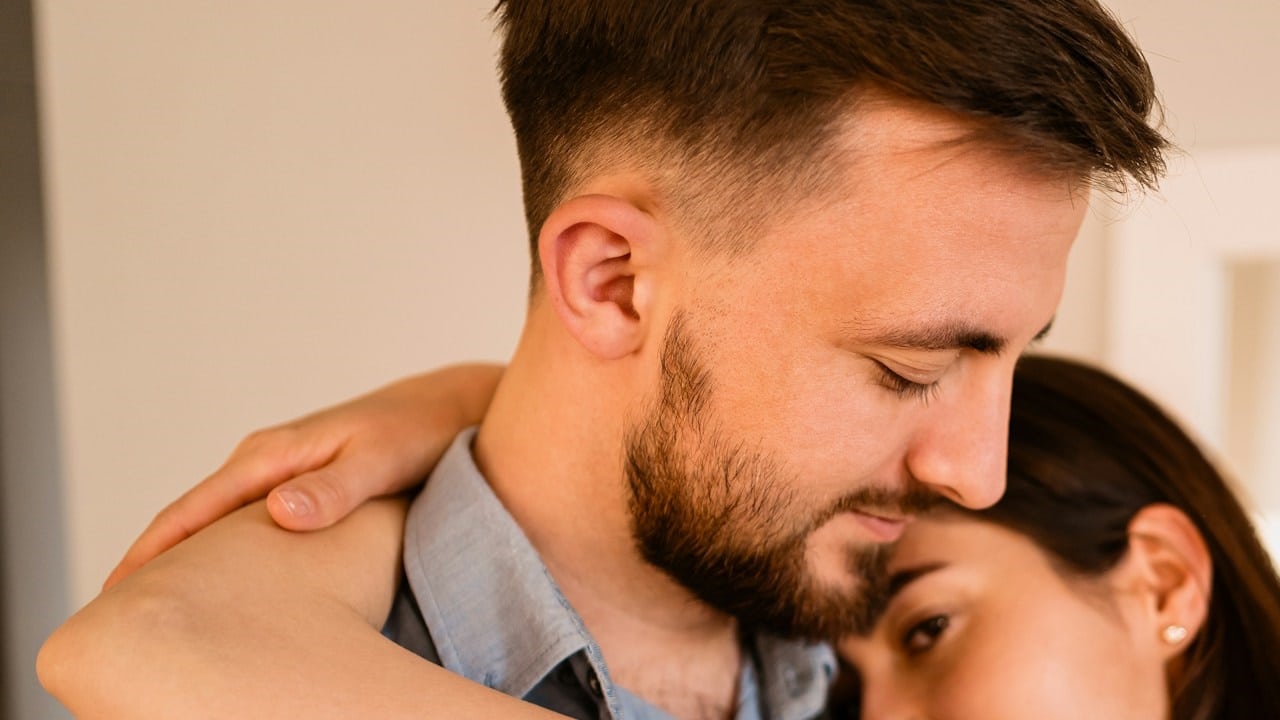 A lovely couple hugging each other, smiling, enjoying time together.