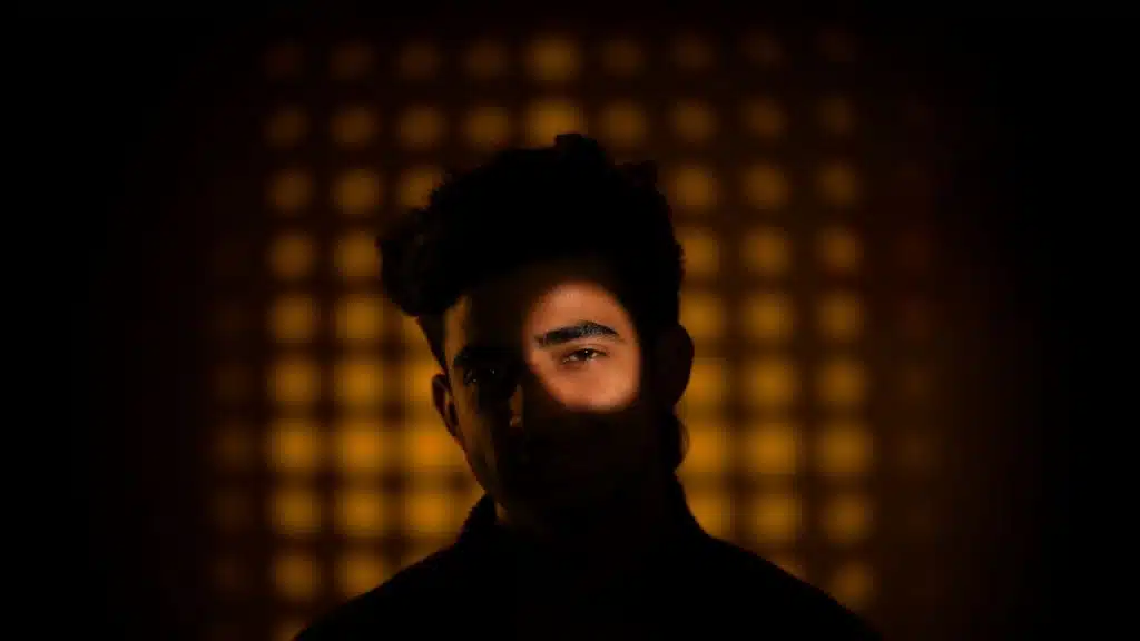 A man has one eye lit.