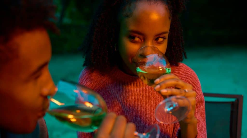 A man and a woman are sitting at a table drinking wine.