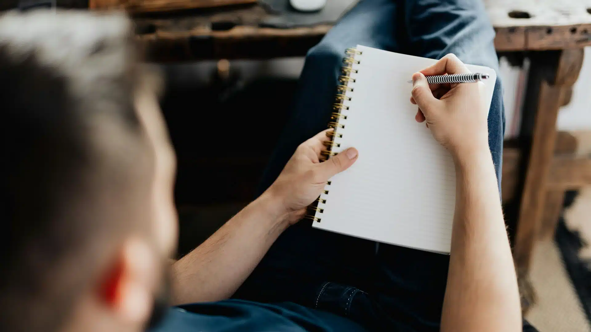 A man writing in a notebook.