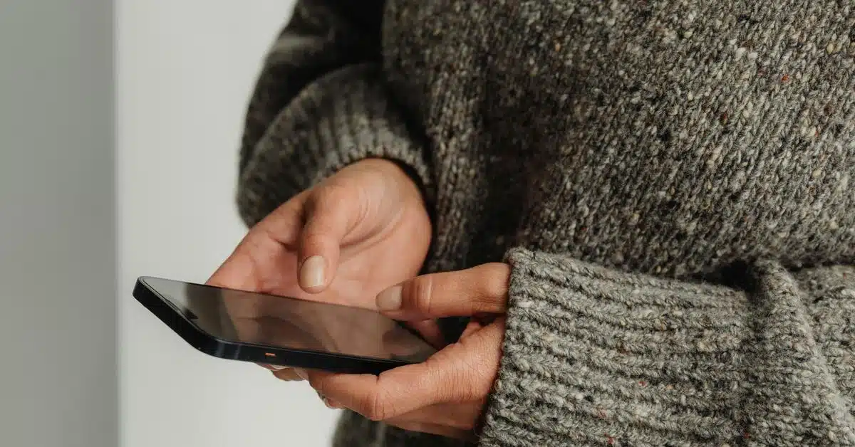 A person holding and using a smartphone with both hands.