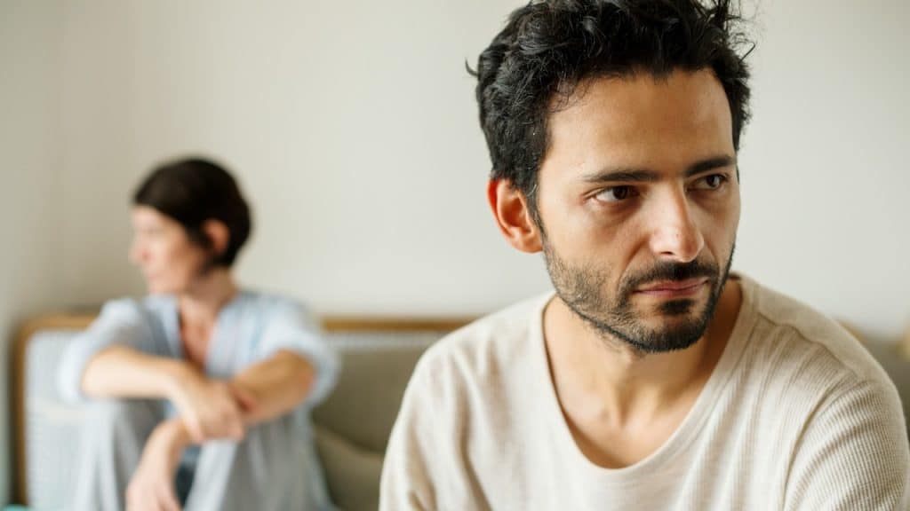 A man and a woman are sitting, upset after having an argument.