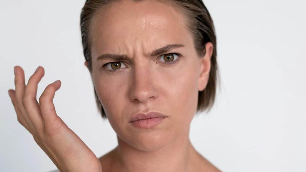 A confused woman looking forward with a puzzled expression.