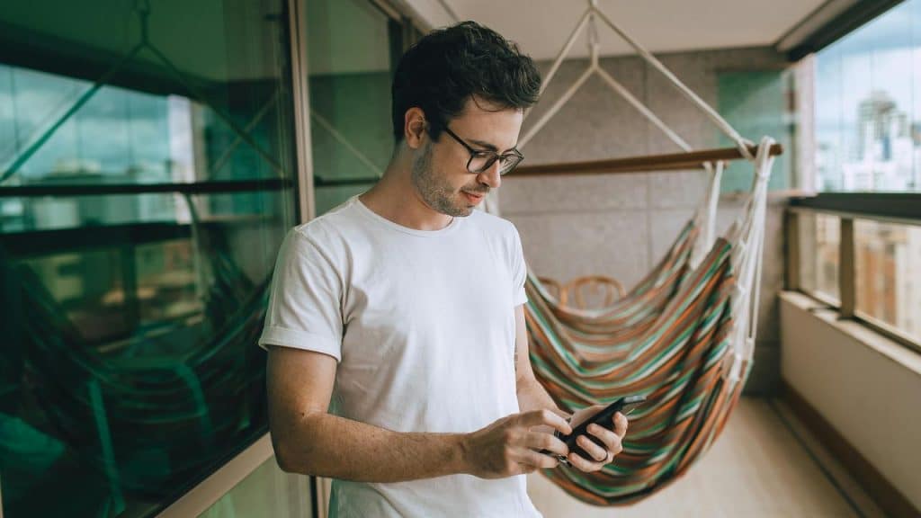 A man standing on a balcony using his phone