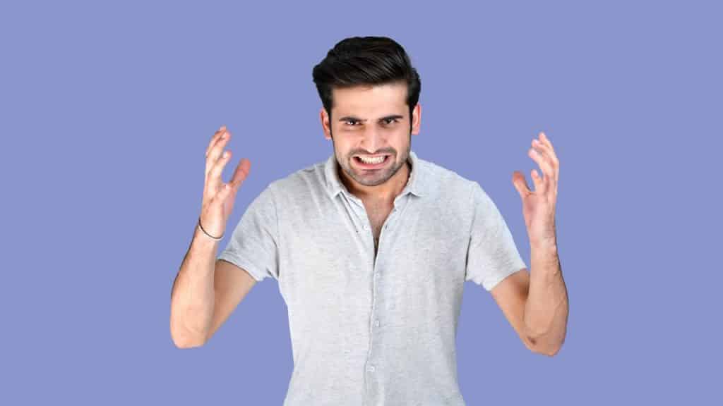 An angry man gesturing with his hands and baring his teeth.