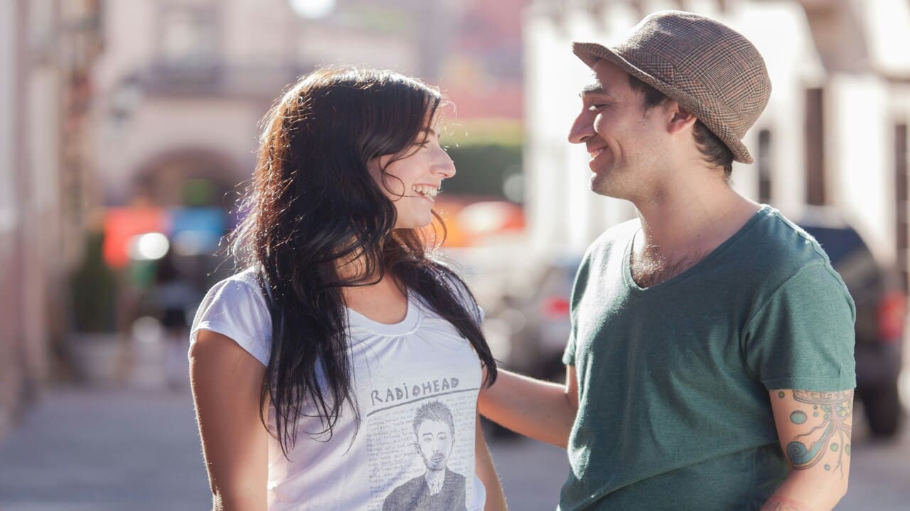 A couple smiling at each other outdoors