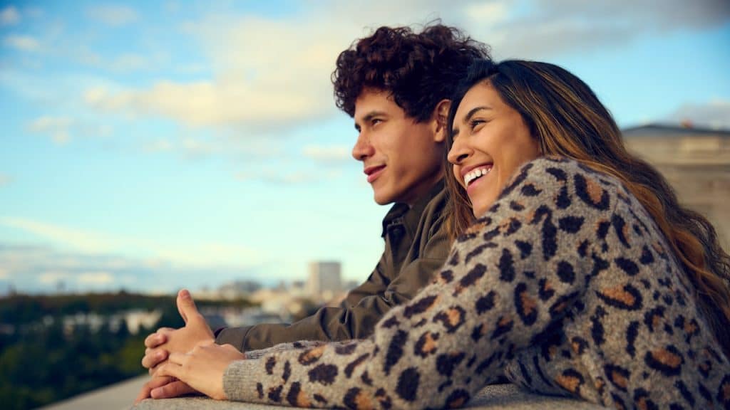 A man and a woman are sitting on a ledge.
