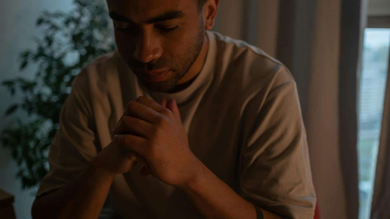 A man sitting with clasped hands