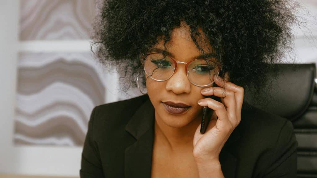 A woman wearing glasses talking on a phone.