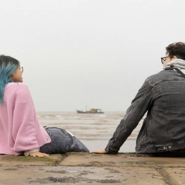 couple sitting together but feeling emotionally distant