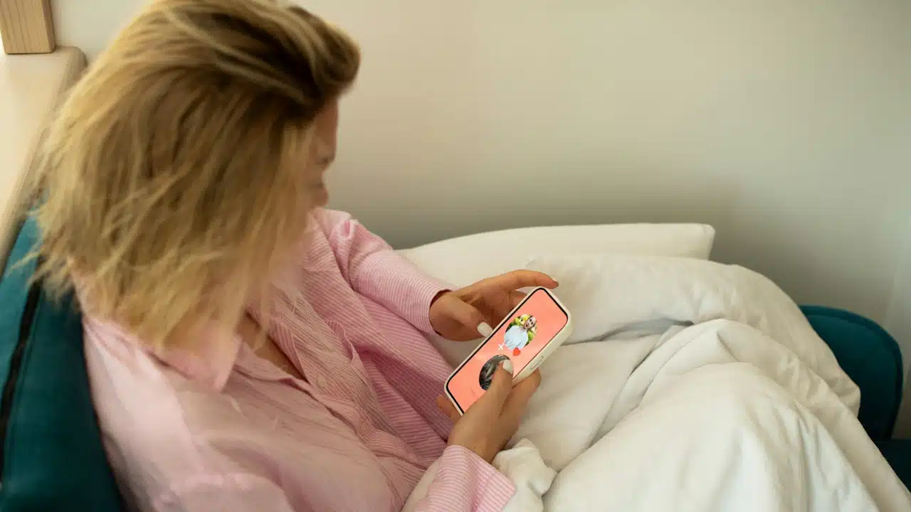 A woman holding a cellphone is using a dating app on it.