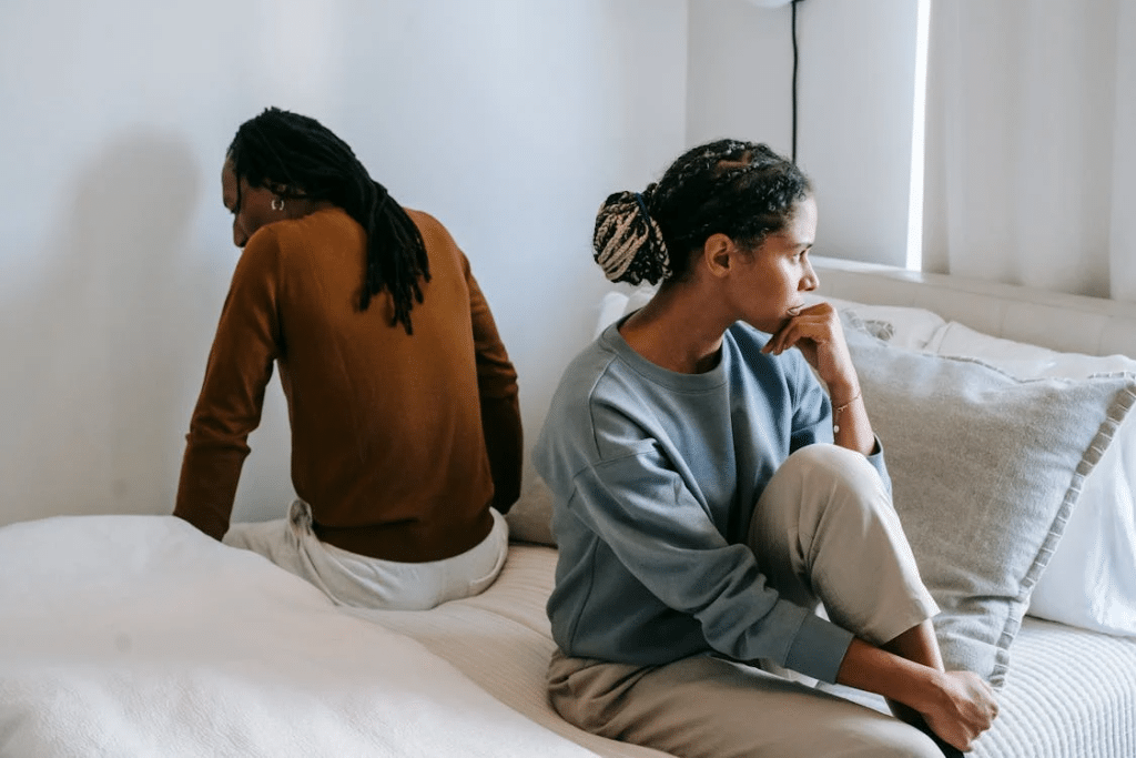 Upset couple sitting on the bed apart from each other