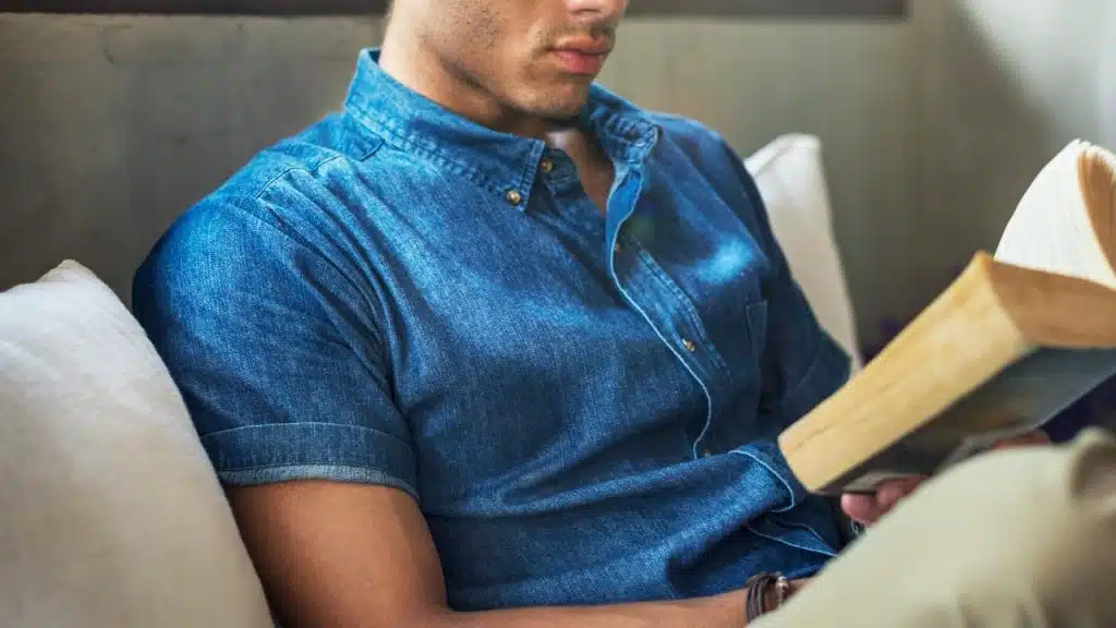A person sitting on a couch reading a book.