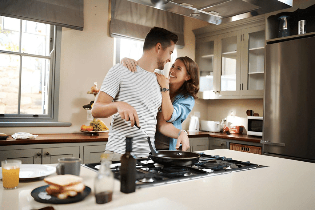 Woman embracing her partner while he cooks