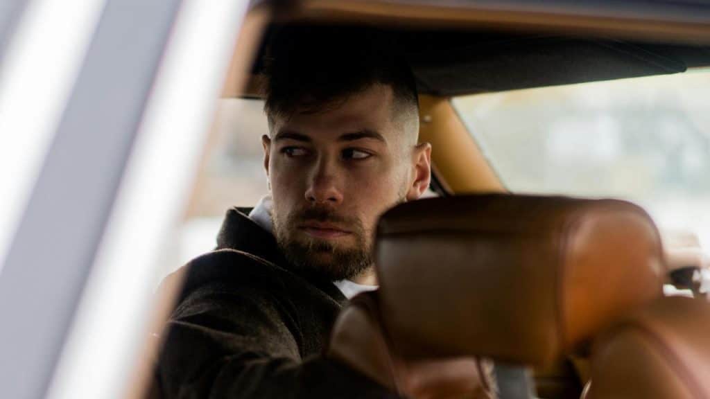 A man sitting in a car looking to the side