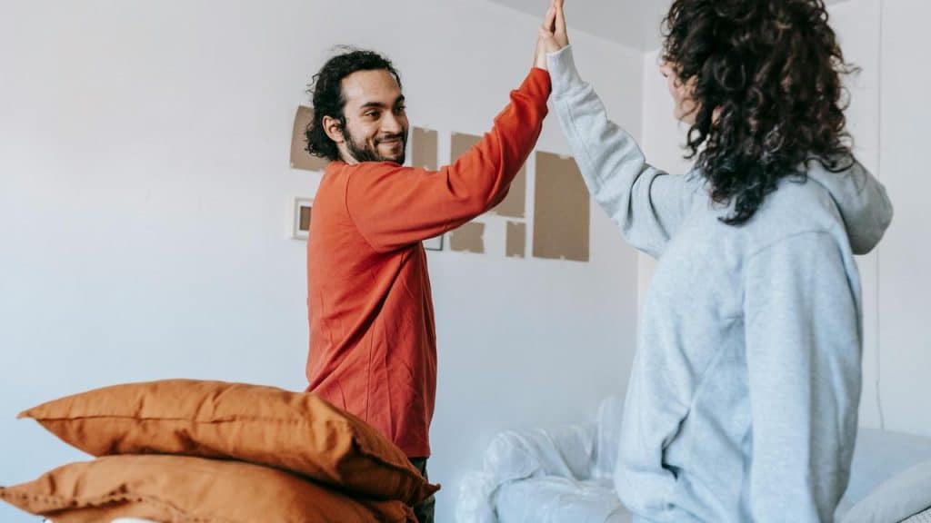 A couple giving each other a high five in a living room
