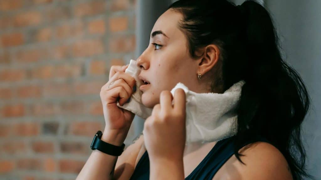 A woman wiping sweat from her face with a towel after a workout.You don't need a gym membership, a Peloton, or some influencer's workout program. You need to move your body. Walk around the block. Do pushups in your living room. Dance like an idiot while you make breakfast (no one's watching anyway).