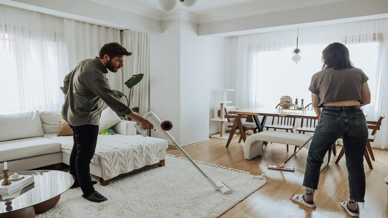 A couple cleaning the living room together