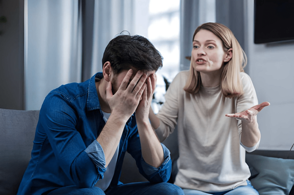 Man avoiding conflict from upset wife in living room