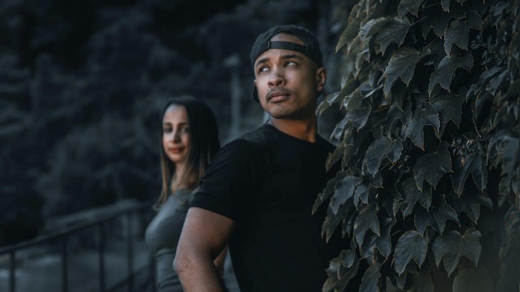 Man in a black crewneck t-shirt standing beside a woman in a black crewneck t-shirt.