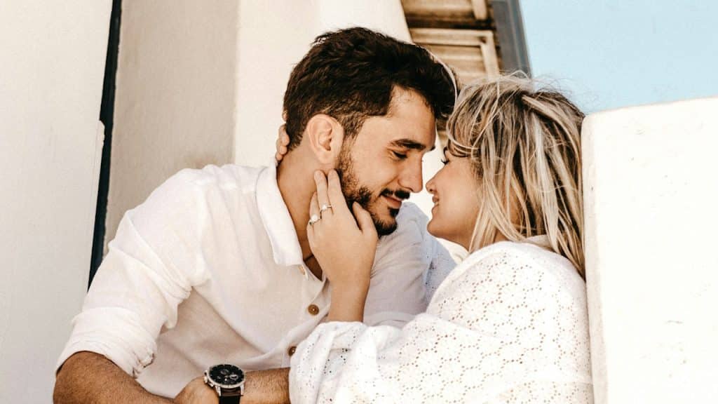 A smiling man and woman are about to kiss.