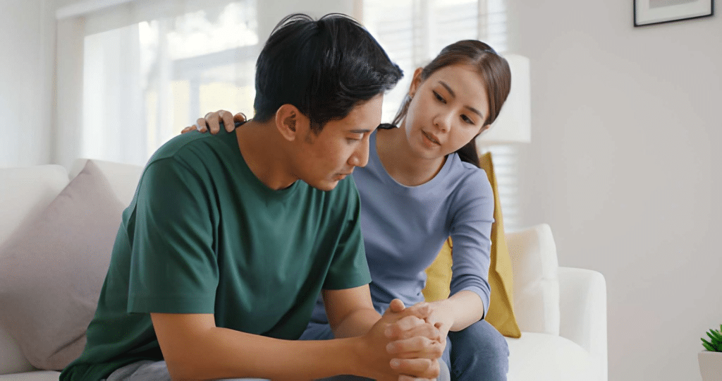 Woman comforting distressed man in living room