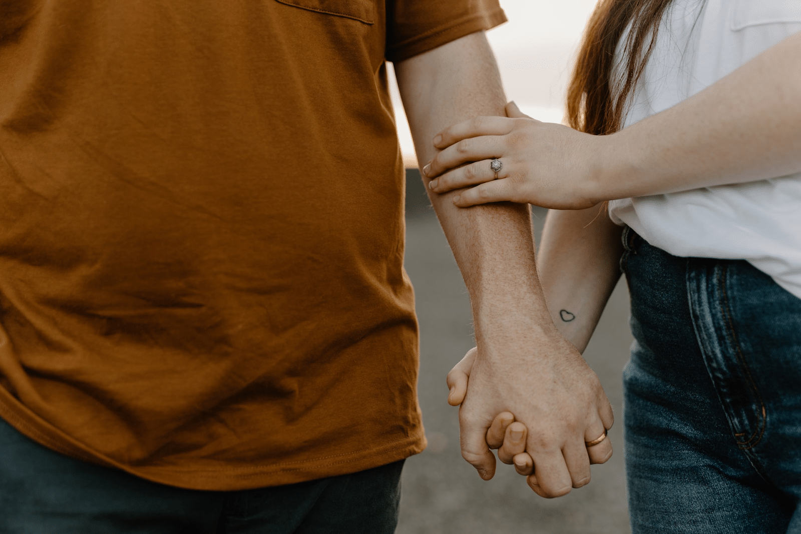 A close up of a couple holding their hands.