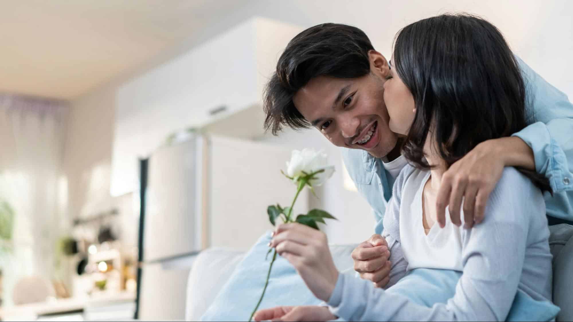 A man giving flower to woman