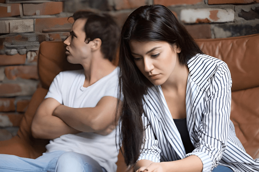 Pensive woman sitting on couch across from avoidant man