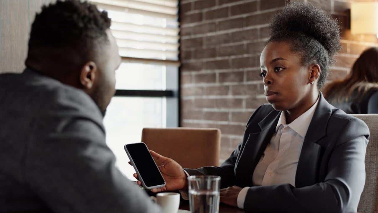 A rude girl showing something on her phone to her boyfriend.