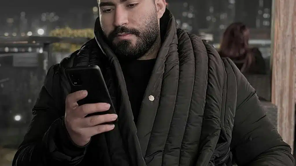 A person looking at a smartphone at night.