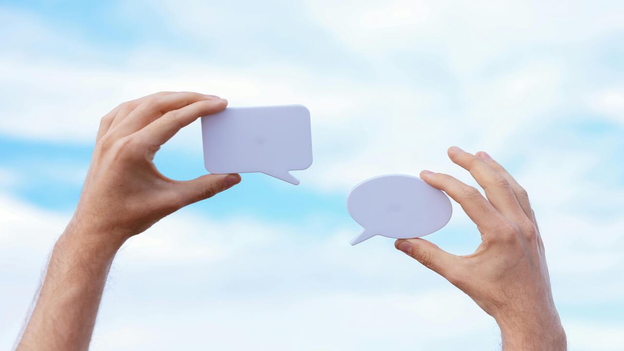 A person holding chat bubbles