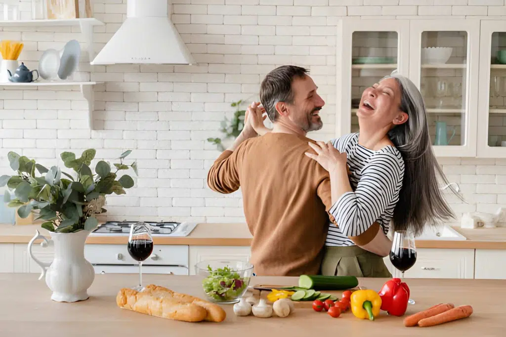 Cheerful couple dancing together in the kitchen