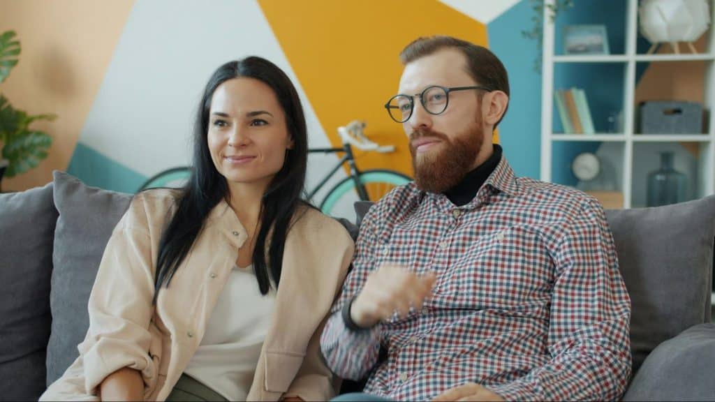 A woman smiling and a man looking worried
