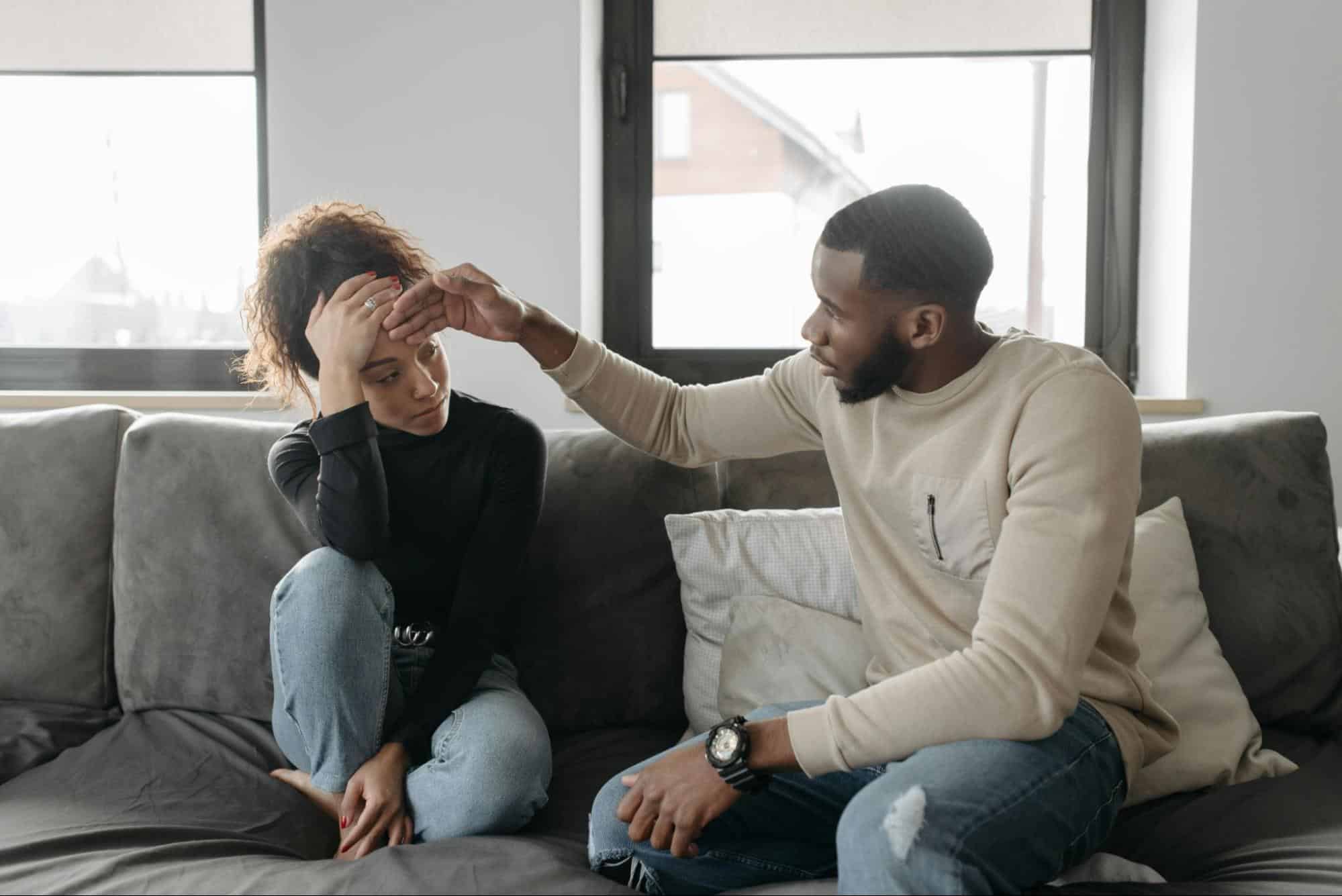 A man touching a woman’s forehead.
