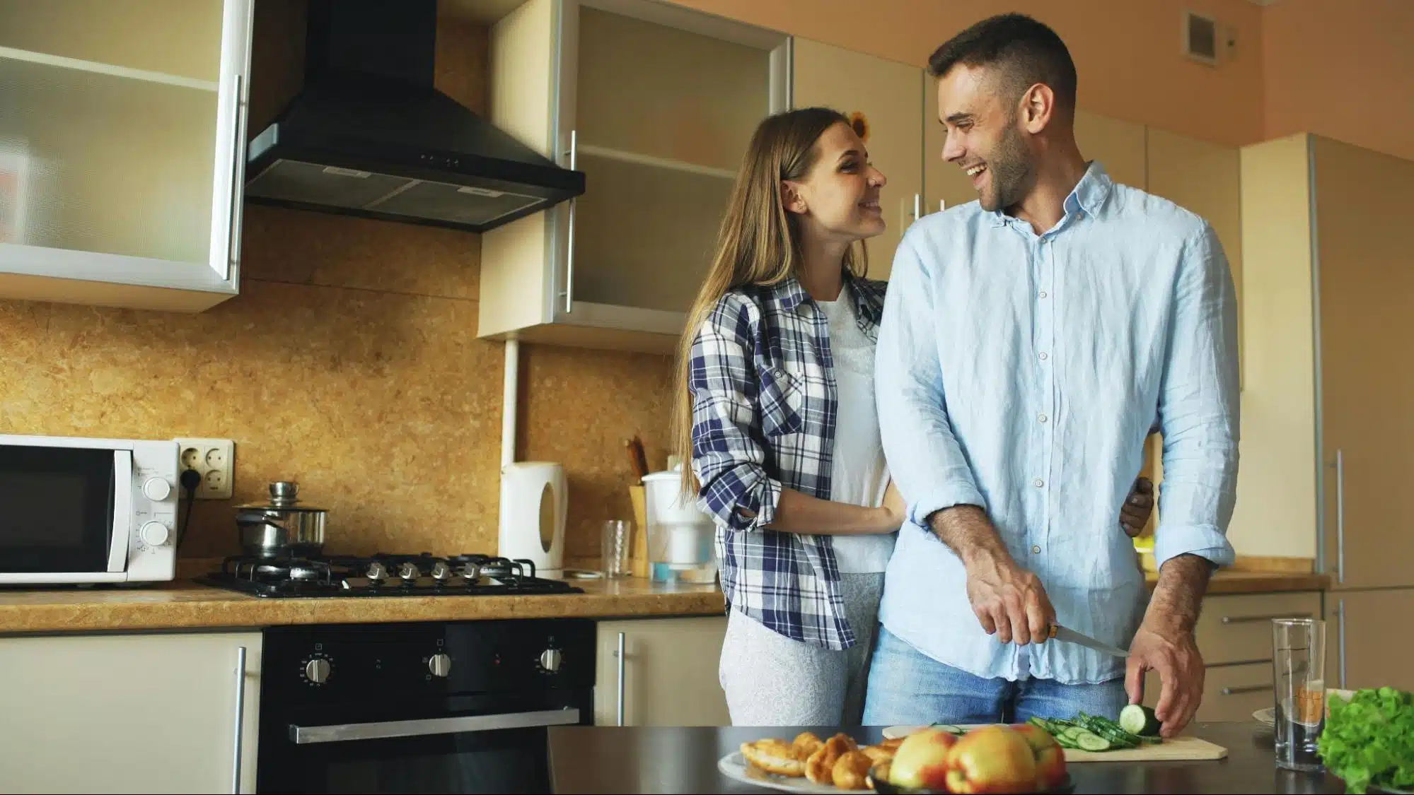 Happy couple cooking together in the kitchen.