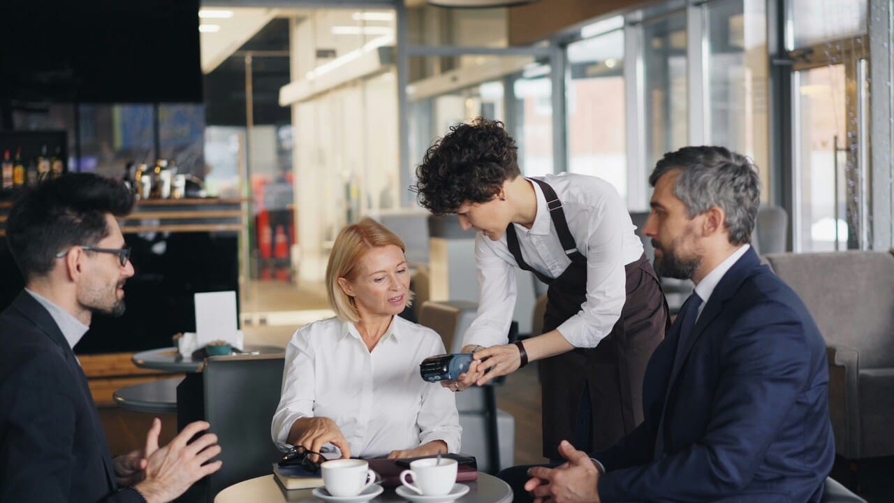 Colleagues talking to a waiter