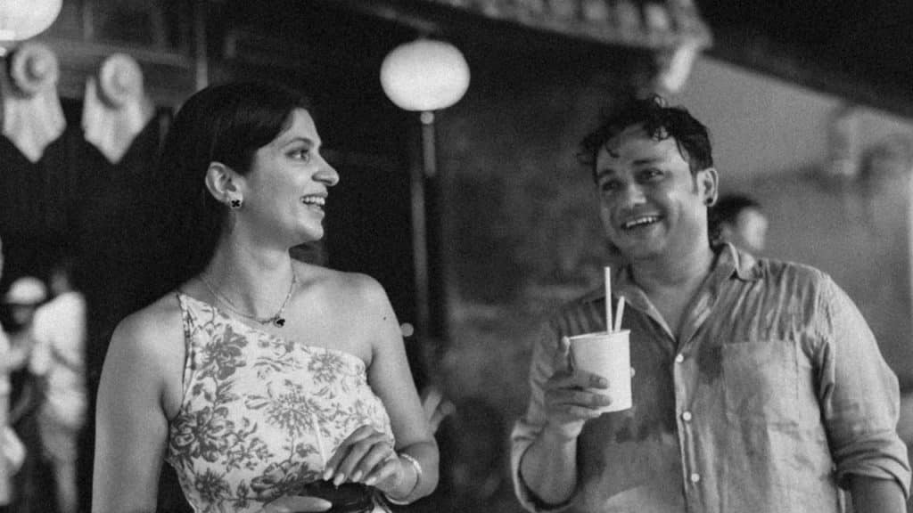 Couple enjoying drinks at night on a street.