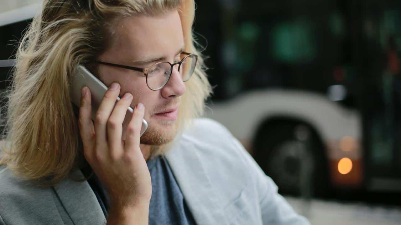 A man with glasses talking on a smartphone.